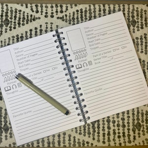May include: A white book with black lines and text for tracking books read. The book has a spiral binding and is open to a page with the title "Title:" and "Author:".
