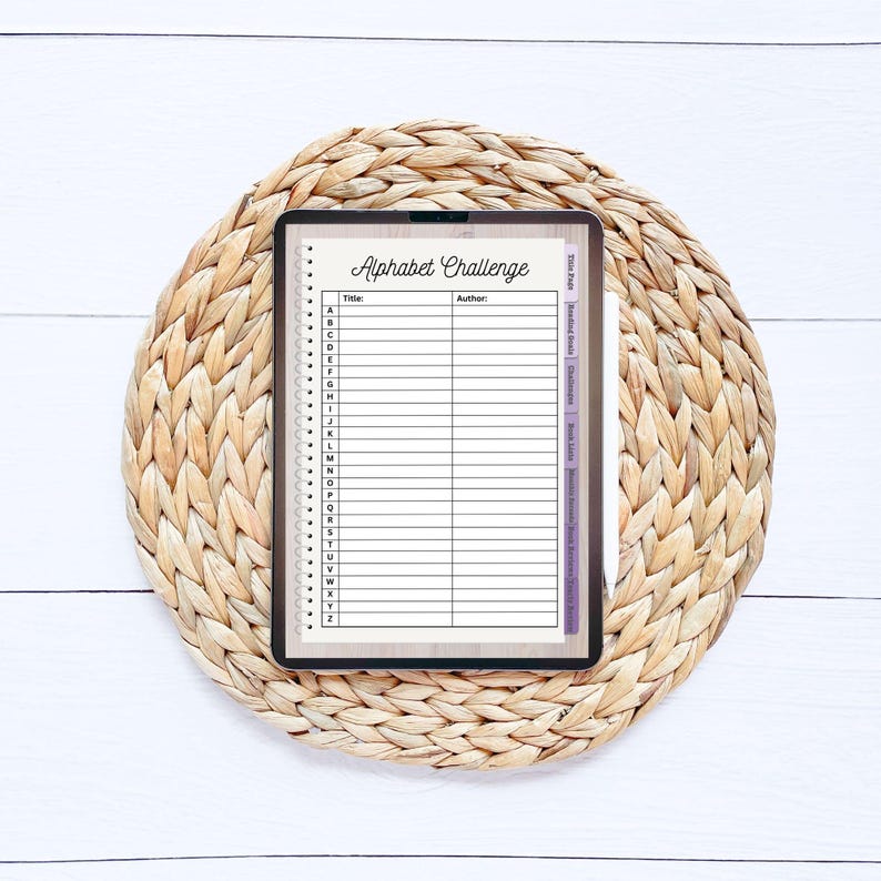 May include: A digital tablet displaying a printable alphabet challenge list. The list includes spaces for the title, author, and book titles for each letter of the alphabet.