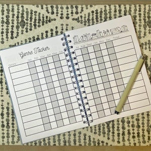 May include: A black and white book tracker with a grid for logging books read by genre and month. The cover features a row of books with the text "Genre Tracker" at the top.