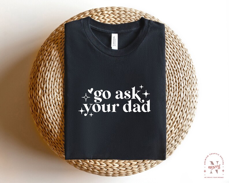 May include: Black t-shirt with white text that says "go ask your dad" with a heart and stars around the text.