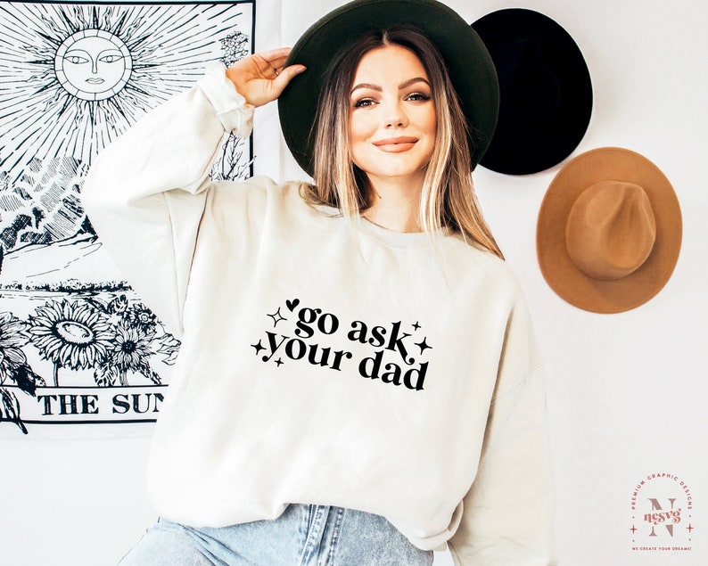 May include: A white sweatshirt with the text "go ask your dad" in black lettering with a heart and stars.