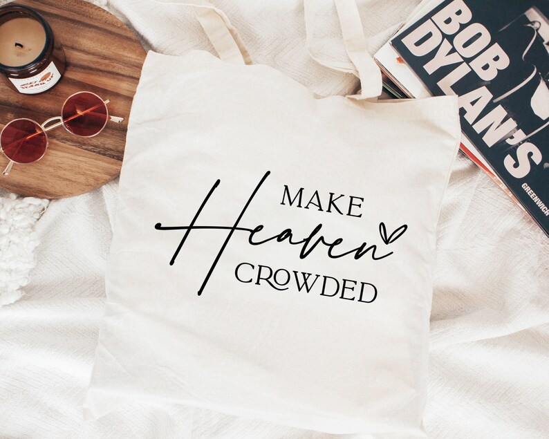 Puede incluir: Bolsa de tela blanca con texto negro que dice "Make Heaven Crowded" con un peque&ntilde;o s&iacute;mbolo de coraz&oacute;n.
