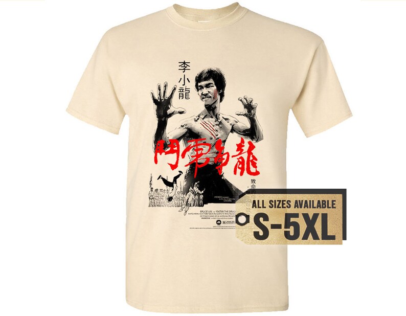 May include: A beige t-shirt with a black and white image of Bruce Lee in a fighting pose. The image is from the movie "Enter the Dragon" and includes the Chinese characters for "Enter the Dragon". The text "All Sizes Available S-5XL" is printed on a brown tag.