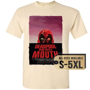May include: Cream-colored t-shirt featuring a graphic of Deadpool's face with the text "DEADPOOL MERC WITH A MOUTH." The design includes a red skull and a purple background. The tag indicates sizes S-5XL.