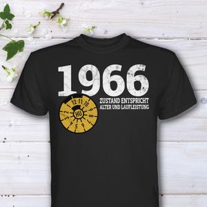 Könnte beinhalten: Schwarzes T-Shirt mit der Jahreszahl "1966" in Weiß. Darunter befindet sich eine gelb-schwarze Grafik mit dem Text "HU". Der Text "ZUSTAND ENTSPRICHT ALTER UND LAUFLEISTUNG" ist ebenfalls auf dem T-Shirt aufgedruckt.
