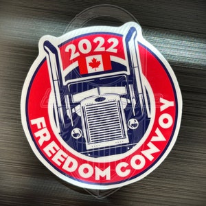 May include: A circular sticker with a red and white border. The sticker features a blue and white illustration of a semi-truck with the Canadian flag and the year 2022. The words "FREEDOM CONVOY" are printed around the truck.