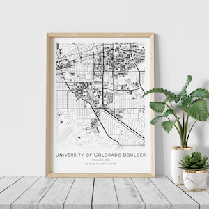 Könnte beinhalten: Schwarz-weiß-Kartendruck des Campus der University of Colorado Boulder in einem hellen Holzrahmen. Die Karte zeigt die Anordnung des Campus mit Gebäuden und Straßen. Der Text unter der Karte lautet "University of Colorado Boulder, Boulder, CO, 40° 0' 33" N, 105° 18' 34" W."