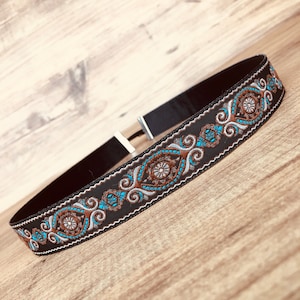Hat band for cowboy hat in black, brown, blue and silver colors.