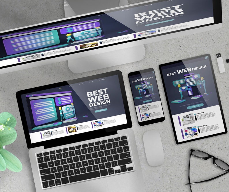 May include: A laptop, desktop monitor, tablet, and smartphone displaying a website design with the text "BEST WEB DESIGN." The devices are arranged on a light gray surface, with a mouse, glasses, and a USB drive nearby. The website design features purple and teal elements.