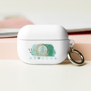 May include: White AirPod case with a teal and gold watercolor design. The design features a circular emblem with a blue character, surrounded by teal and gold accents, and several small symbols below.