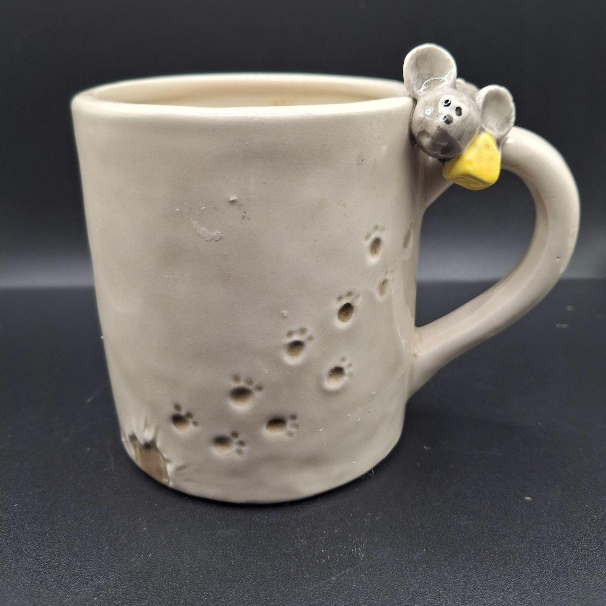 ネズミをモチーフにした陶器のマグカップ。ネズミとチーズの柄付き