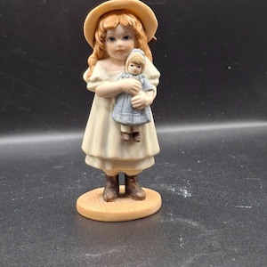 Jan Hagara Lori 1979 Estatueta de porcelana menina segurando boneca vintage colecionável