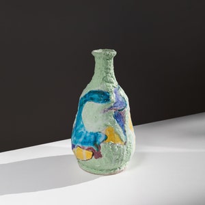 Può includere: Un vaso in ceramica verde con una superficie testurizzata e disegni astratti blu, gialli e viola.