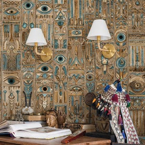 May include: An interior design scene featuring a detailed wall with an ancient Egyptian motif in shades of brown, teal, and gold. Two sconces with white shades are mounted on the wall. A desk holds books, a bust, and decorative items.