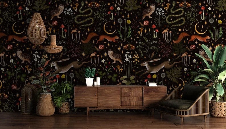 May include: A dark brown wooden console table with a black chair and two potted plants in front of it. The wall behind the furniture is covered in a black wallpaper with a repeating pattern of animals, plants, and mushrooms.