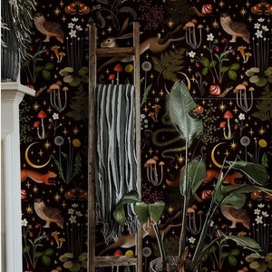 May include: A black and white wallpaper with a repeating pattern of woodland creatures, mushrooms, and stars. The wallpaper is displayed on a wall with a wooden ladder and a potted plant in front of it.