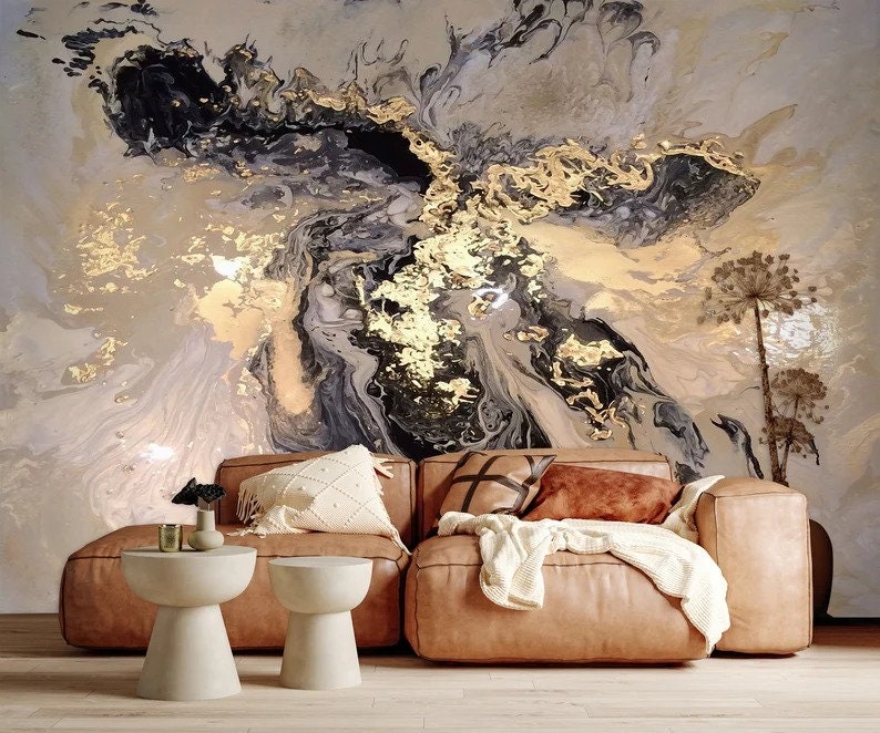 May include: A brown leather sectional sofa with white and brown throw pillows in front of a wall with a large abstract painting featuring black, gold, and white swirls.