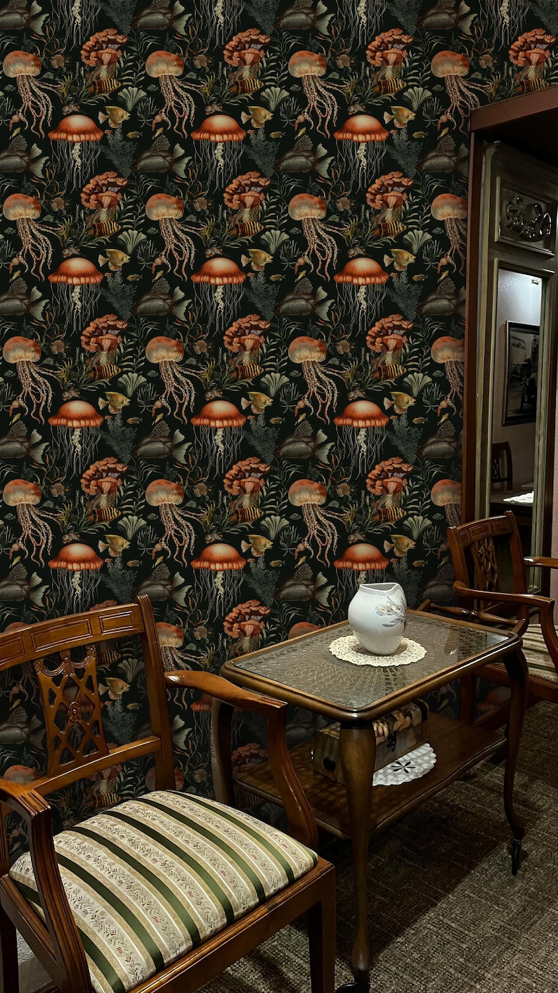May include: Dark wallpaper featuring a repeating pattern of orange jellyfish, fish, and seaweed on a black background. The room includes wooden furniture, a glass-topped table, and a white vase.
