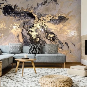 May include: A living room interior design with a sectional sofa, a coffee table, a rug, and a fireplace. The wall behind the sofa features a large abstract painting with black, gold, and white swirls.
