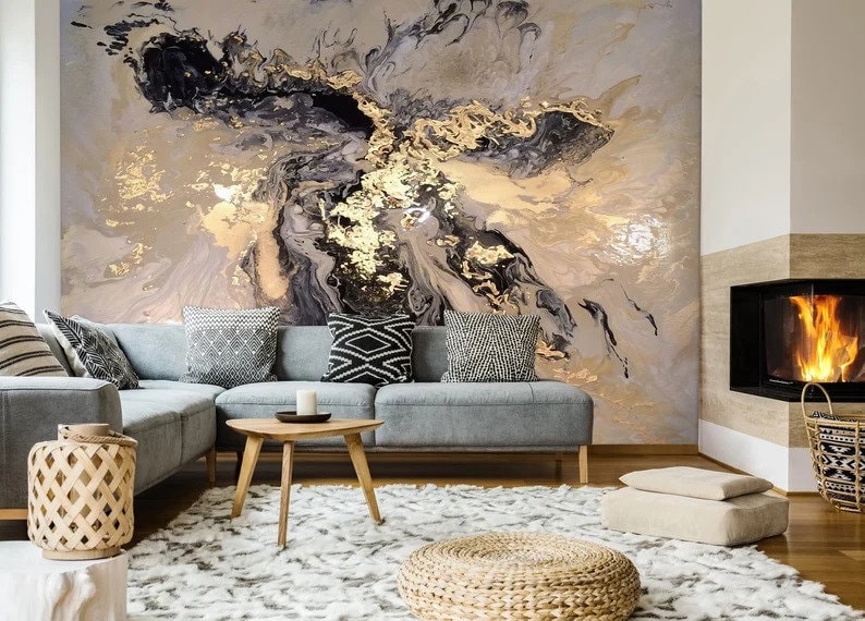May include: A living room interior design with a sectional sofa, a coffee table, a rug, and a fireplace. The wall behind the sofa features a large abstract painting with black, gold, and white swirls.