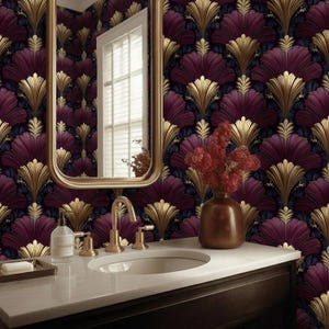 Può includere: Un bagno con uno specchio con cornice dorata, un piano di lavoro bianco e un lavandino. La carta da parati presenta un motivo ripetuto di forme a ventaglio dorate e viola intenso. Un vaso di bronzo contiene fiori rossi.