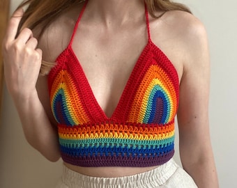 Puede incluir: Un top de crochet arcoíris con estilo de cuello halter. El top está hecho con una variedad de colores, incluyendo rojo, naranja, amarillo, verde, azul, índigo y violeta.