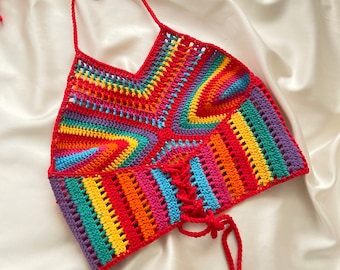 Puede incluir: Un top halter de crochet arcoíris con cierre de nudo. El top está hecho con una variedad de colores, incluyendo rojo, naranja, amarillo, verde, azul y morado.
