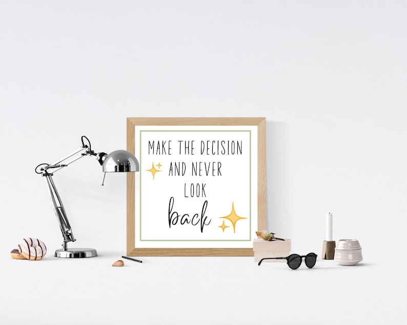 May include: A framed print with a white background and green border. The print features the text "Make the decision and never look back" in black with yellow stars.