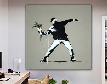 May include: A black and white stencil art print of a person throwing a bouquet of flowers. The person is wearing a black hooded jacket, white pants, and a black mask. The background is a light gray color.