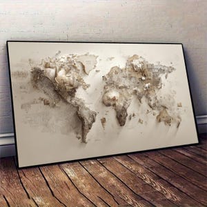 May include: A framed world map artwork with a 3D relief design. The map uses a neutral colour palette of beige and brown, creating a textured, artistic representation of the continents and oceans. The artwork is displayed on a white background.