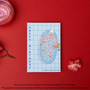 Può includere: Un biglietto di auguri di compleanno con le parole "HAPPY BIRTHDAY" in testo verticale. La carta presenta un'illustrazione di una persona che si rilassa in una vasca da bagno piena di bolle e fiori. È presente anche il testo "Dive into a year full of relax".