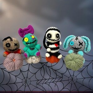 Peut inclure: Quatre personnages d'Halloween en crochet assis sur des citrouilles. Les personnages sont un monstre vert, un squelette rayé noir et blanc, un monstre bleu et gris, et un monstre gris avec un cœur rouge.