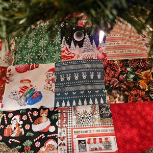 May include: A patchwork Christmas tree skirt with a variety of holiday-themed fabrics, including cats, reindeer, snowflakes, candy canes, and a winter scene. The skirt is made up of 12 different squares of fabric, each with a unique design.