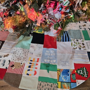 Könnte beinhalten: Ein Patchwork-Weihnachtsbaumrock aus verschiedenen Stoffen, darunter ein rot-weiß gestreiftes Stoff, ein grüner Stoff mit einem Weihnachtsbaumdesign und ein blauer Stoff mit einem Dinosaurierdesign. Der Rock hat auch mehrere Patches mit Text, darunter "Mom + Dad + Me", "And Then There Were Four" und "Handpicked Earth Grown Food Heaven".