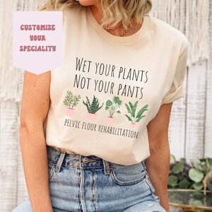 May include: A light beige t-shirt with the text "Wet your plants not your pants" and a row of potted plants. The text "Pelvic floor rehabilitation" is below the plants.