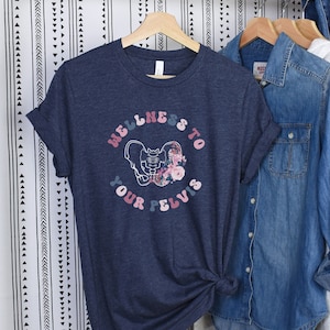 May include: A navy blue t-shirt with a graphic of a pelvis with flowers and the text "Wellness to your pelvis".