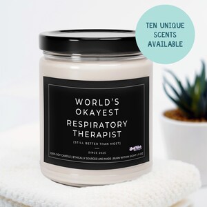 May include: A white soy candle with a black label that reads "World's Okayest Respiratory Therapist (Still Better Than Most)"  Since 2025. 100% Soy Candle | Ethically Sourced and Made | Burn Within Sight | 9 oz.