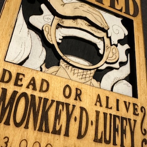 Pode incluir: Um cartaz de procurado de madeira com uma imagem de desenho animado de Monkey D. Luffy do anime One Piece. O cartaz &eacute; marrom com texto preto que diz "Morto ou vivo? Monkey D. Luffy".