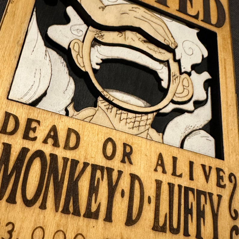 Pode incluir: Um cartaz de procurado de madeira com uma imagem de desenho animado de Monkey D. Luffy do anime One Piece. O cartaz &eacute; marrom com texto preto que diz "Morto ou vivo? Monkey D. Luffy".