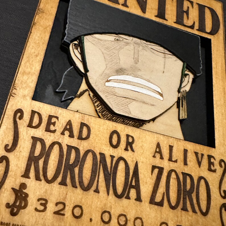 Pode incluir: Um cartaz de procurado de madeira com uma imagem de desenho animado de um homem com cabelo preto e uma bandana preta. O cartaz diz "DEAD OR ALIVE" e "RORONOA ZORO" com uma recompensa de $ 320.000.000.