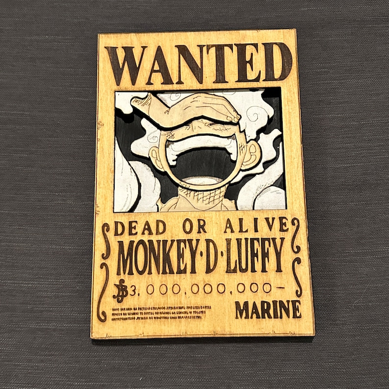 Pode incluir: Um cartaz de procura de madeira com uma imagem de desenho animado de Monkey D. Luffy do anime One Piece. O cartaz tem o texto "WANTED", "DEAD OR ALIVE", "MONKEY-D-LUFFY", "$3.000.000.000-" e "MARINE".