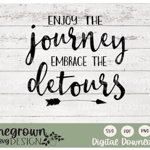 May include: Black and white text graphic on a white wood background. The text reads "Enjoy the journey, embrace the detours".  There is a small arrow graphic below the text.