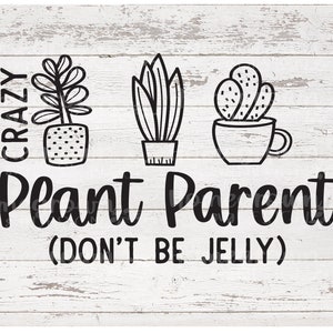 May include: A white wood sign with black text that reads "Crazy Plant Parent (Don't Be Jelly)". The sign features three black and white illustrations of potted plants.