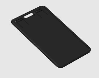 Puede incluir: Un porta-credenciales rectangular negro con una ranura para un cordón y dos ranuras adicionales. El soporte está hecho de un material liso y mate y está ligeramente inclinado.