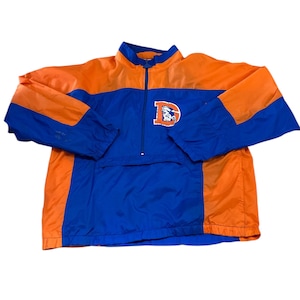 May include: A vintage Denver Broncos half-zip windbreaker jacket. The jacket features a colour block design with orange and blue panels. The Broncos logo is embroidered on the chest. The jacket has a stand-up collar and a front zip.