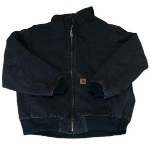 May include: Black work jacket with a full zipper closure, ribbed cuffs, and a ribbed hem. The jacket features a brown square logo patch on the front and a high collar. The jacket is made of a durable, heavy-duty fabric.