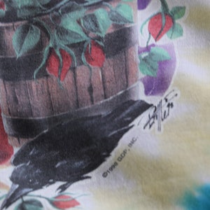 May include: A tie-dye t-shirt with a black crow and a wooden bucket filled with red roses and green leaves. The shirt has the text "&copy;1998 GDP, INC." and a signature.