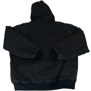 May include: A black hooded jacket with a full-length zipper and ribbed cuffs and hem. The jacket has a hood and long sleeves. The jacket is made of a durable, heavy-duty fabric.