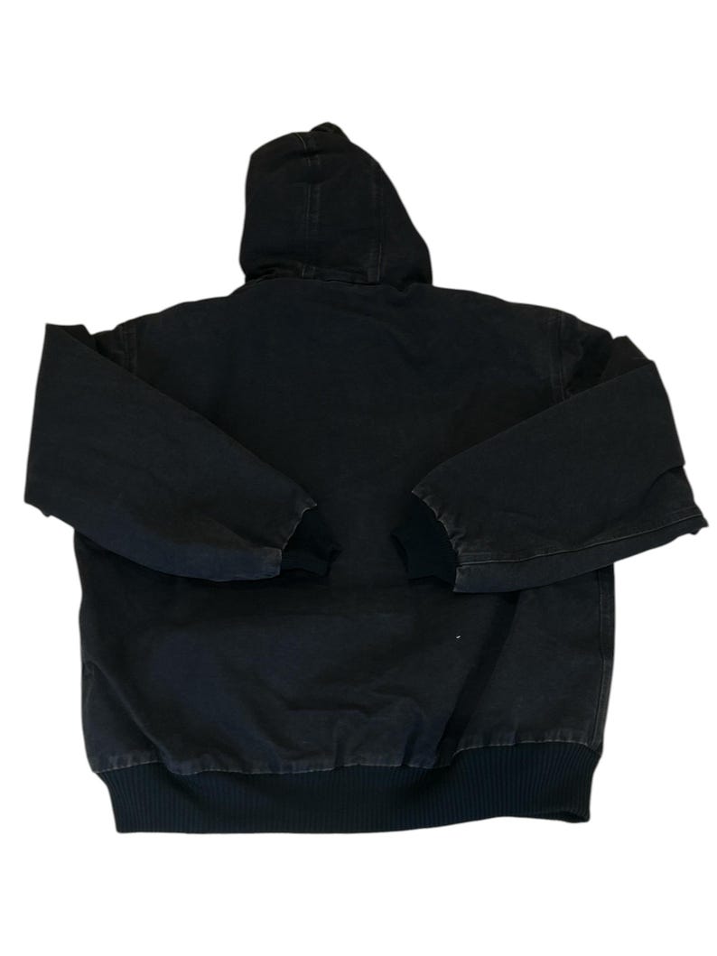 May include: A black hooded jacket with a full-length zipper and ribbed cuffs and hem. The jacket has a hood and long sleeves. The jacket is made of a durable, heavy-duty fabric.