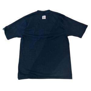 May include: Black short-sleeved t-shirt with a small American flag patch on the back.